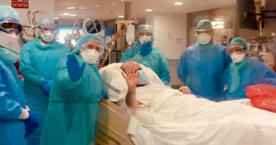 Un hombre en una camilla rodeado de enfermeros con EPIs