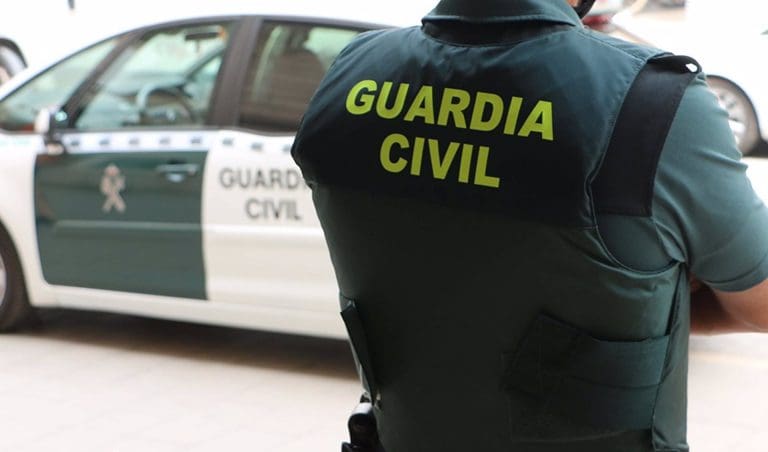 05/06/2022 Un agente de la Guardia Civil, de espaldas, junto a un vehículo oficial