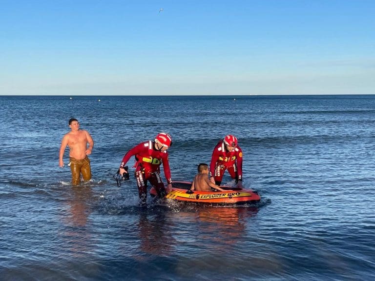 Los bomberos rescatan a un niño  en una barca hinchable en la playa de la Malvarrosa