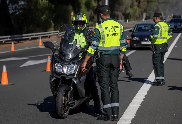 Agente de la Guardia Civil de Tráfico conversando con un motorista
