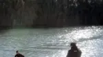 Dos agentes de la Policía Nacional buscan en el río Júcar junto a la orilla.